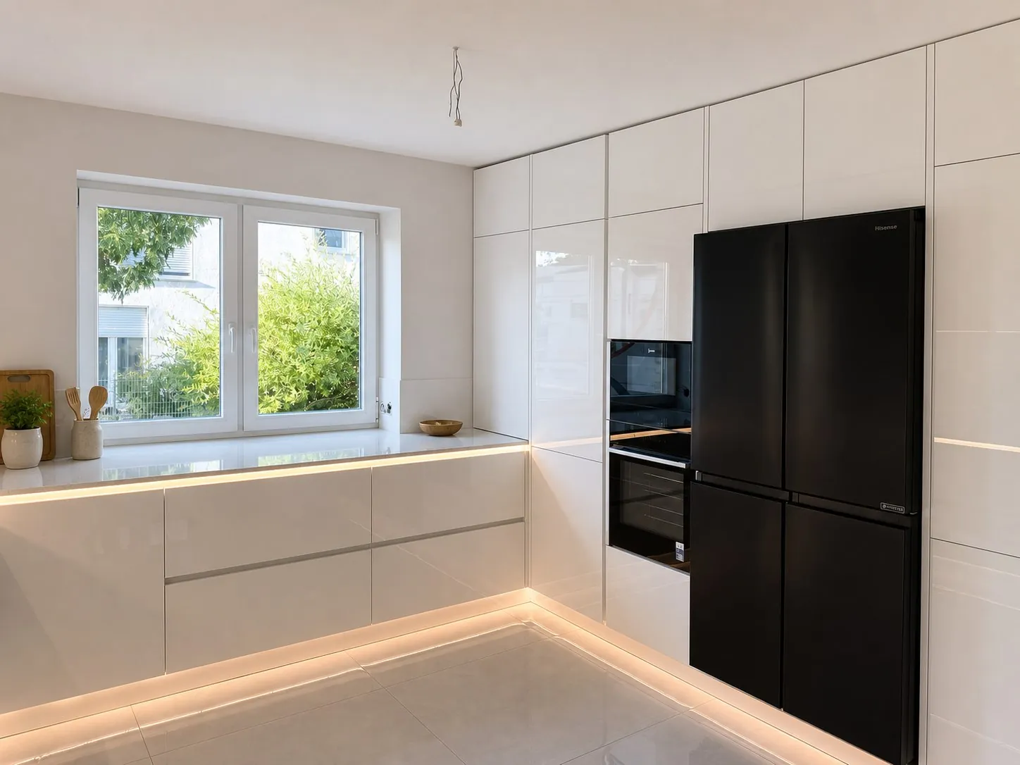 Weiße Hochglanzküche mit Hochschrankwand, eingebautem Backofen und schwarzem Side-by-Side-Kühlschrank