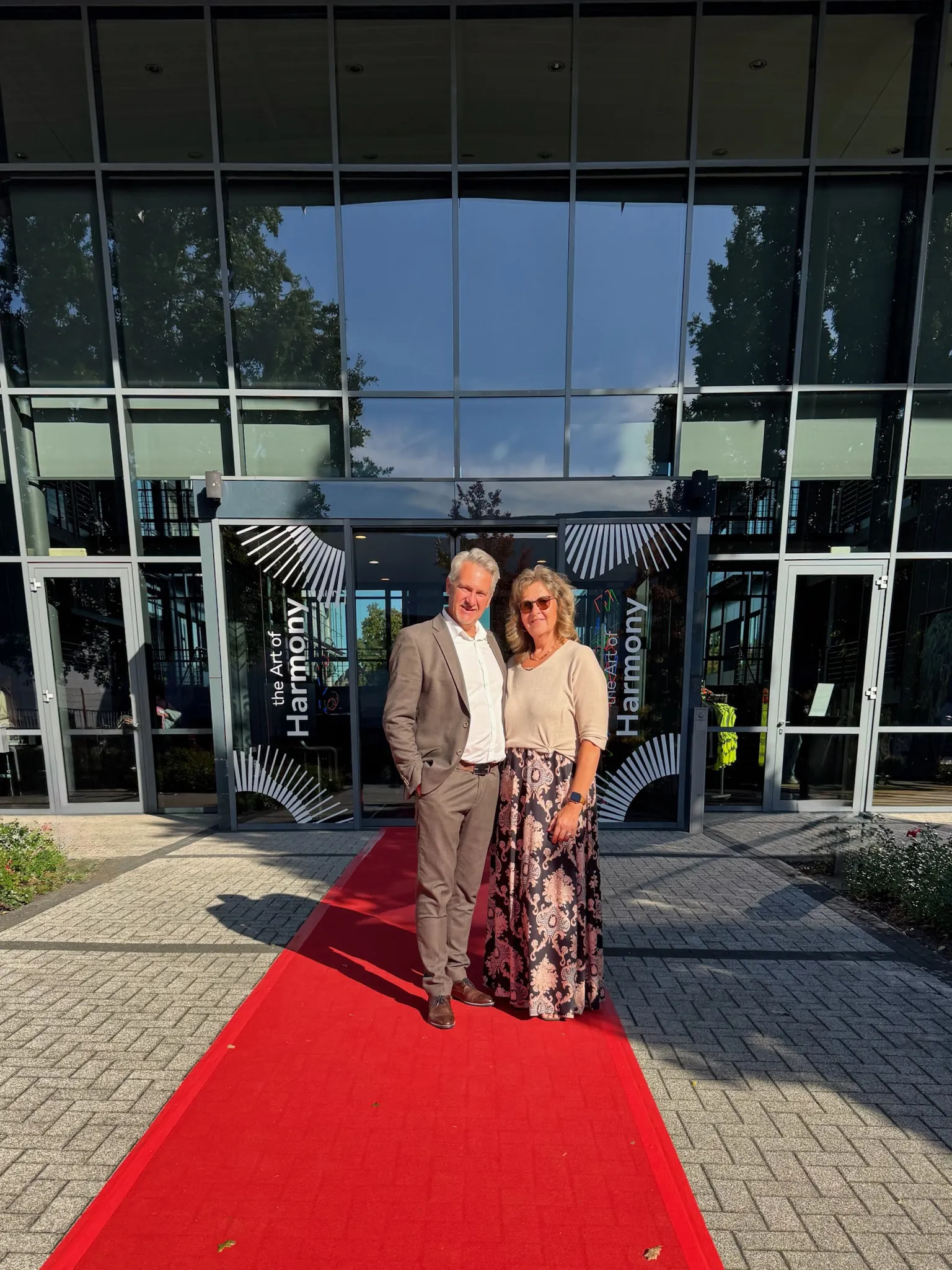Viktor und Elena Frese auf einem roten Teppich vor dem Eingang einer Messe